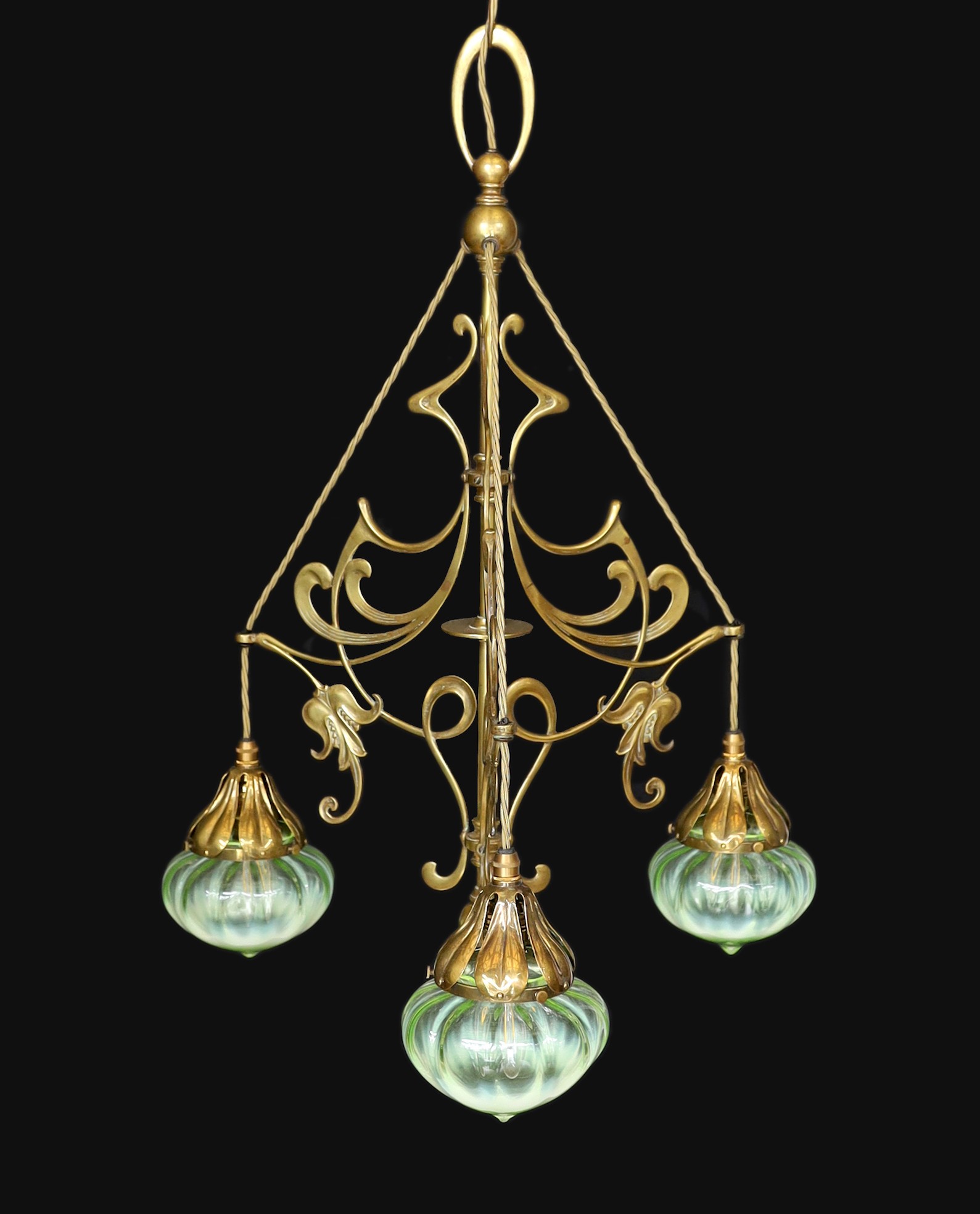 An English Arts & Crafts brass light fitting with scrolling foliate branches and tinted iridescent glass shades, height 68cm. width 46cm